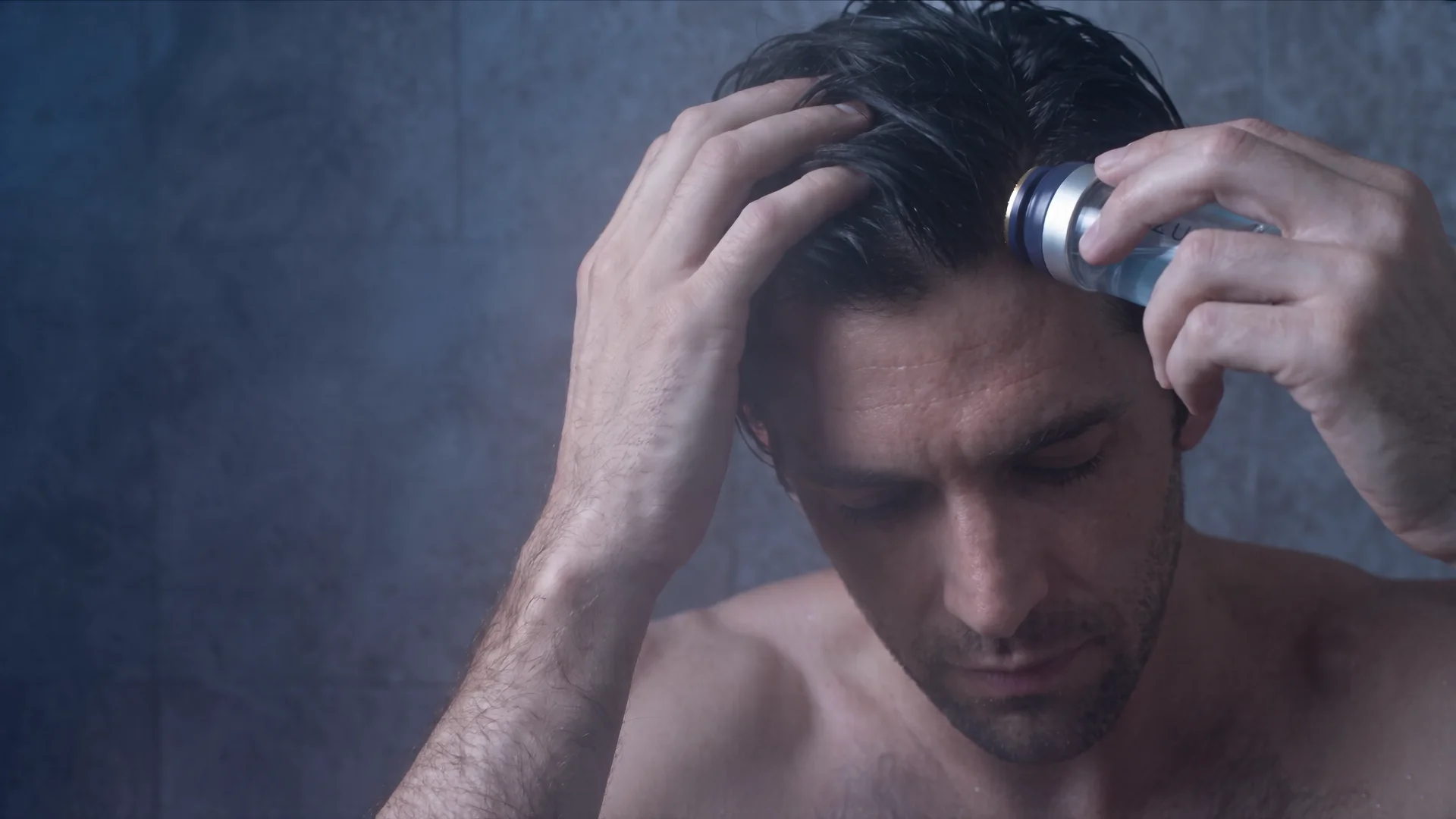 A man pressing the AZURE micro-infusion applicator against his scalp